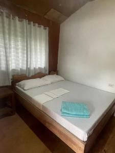 łóżko z niebieskim ręcznikiem na górze w obiekcie Green Soul Port Barton w mieście San Vicente