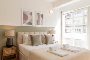 een slaapkamer met een bed met twee handdoeken erop bij Ceuta Studio Apartments by LovelyStay in Porto