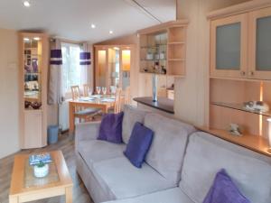 a living room with a white couch and purple pillows at Doggy Dell in Motcombe