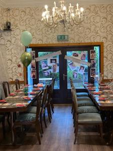 a dining room with long tables and chairs and a chandelier at Tayview Hotel in Dundee