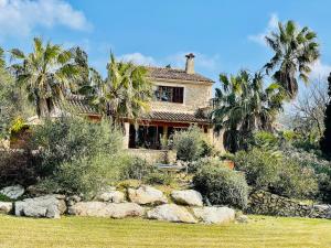 a house with palm trees in front of it at Finca Son Amoyana Capdepera in Capdepera