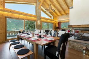 une salle à manger avec une table, des chaises et des fenêtres dans l'établissement Chalet Charbray, à La Tzoumaz