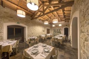 a dining room with tables and chairs and wooden ceilings at Casale Graffetta in Ispica