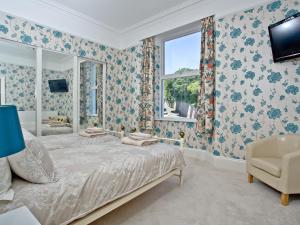 a bedroom with a bed and a window at Riviera Mansion, Torquay in Torquay