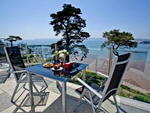 a blue table with a plate of food on a balcony at Riviera Mansion, Torquay in Torquay