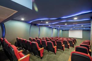 a cinema room with red chairs and a white screen at Granada Luxury Okurcalar in Okurcalar