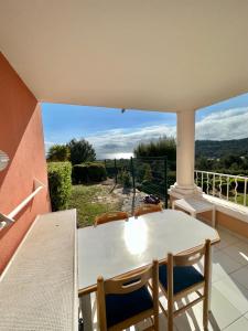 a table and chairs on a balcony with a view at Studio 4 Pers Vue Mer Cap Esterel in Saint-Raphaël