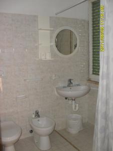 リミニにあるConsul Hotelのバスルーム(洗面台、トイレ、鏡付)