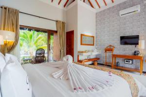 Un dormitorio con una cama blanca con sus alas extendidas en Bintan Exotica Resort en Berakit