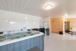 duża łazienka z wanną i umywalką w obiekcie Chalet d’exception avec sauna, jacuzzi, ping-pong w mieście Liézey