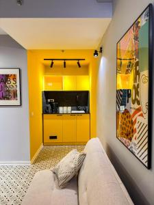 a living room with a couch and a yellow kitchen at Levinski Market Hotel in Tel Aviv