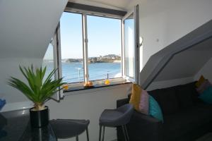 a living room with a couch and a view of the ocean at Sandybanks Torquay - Seaview and Promenade Apartments in Torquay