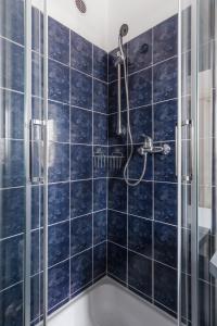 a bathroom with a shower with blue tiles at Sunny Condo in Holešovice by Prague Days in Prague