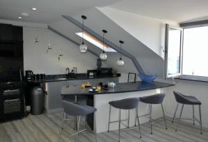 a kitchen with a counter and stools in a room at Sandybanks Torquay - Seaview and Promenade Apartments in Torquay