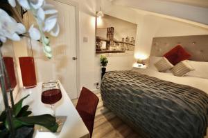 a hotel room with a bed and a table with a wine glass at Sandybanks Torquay - Seaview and Promenade Apartments in Torquay