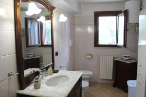 een badkamer met een wastafel, een toilet en een spiegel bij Villa Corvetta in Ostuni +10 foto's