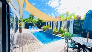 een patio met een zwembad en een tafel en stoelen bij Inave Oasis 3 Bedroom Villa "Your home away from Home" in Arorangi