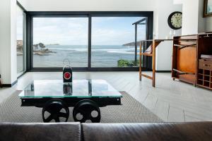 sala de estar con sofá y mesa con reloj en Mundaka Beachfront House, en Mundaka