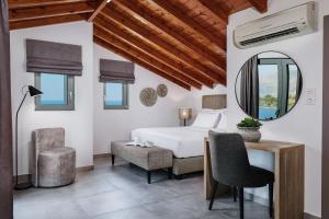 een slaapkamer met een bed, een spiegel en een bureau bij Quattro Suites in Monemvasia