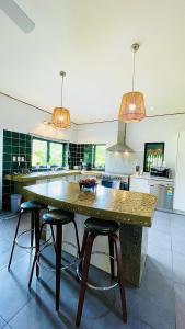 een keuken met een grote tafel en 2 barkrukken bij Inave Oasis 3 Bedroom Villa "Your home away from Home" in Arorangi
