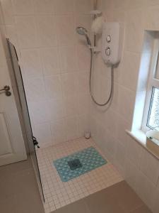 a bathroom with a shower with a tile floor at Coastal Cottage in Dromore West