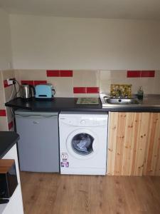 een keuken met een wasmachine en een wastafel bij Coastal Cottage in Dromore West