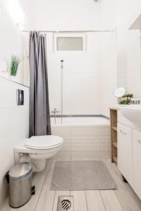 a bathroom with a toilet and a tub and a sink at Elisabeth 52 Apartment in Budapest