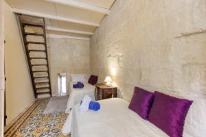 two beds in a room with a brick wall at VLT214- Valletta 2 Bedroom Townhouse in Valletta