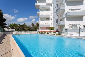 a swimming pool in front of a building at Edificio Flamingo in Gandía