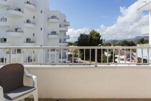 a chair on a balcony with a building at Edificio Flamingo in Gandía