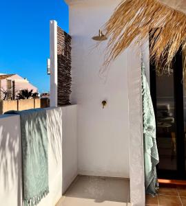 a white building with a straw roof at Casita 10 Málaga, holiday home with roof terrace in Málaga