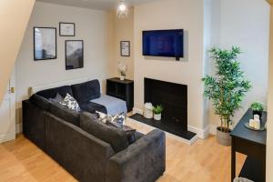 een woonkamer met een bank en een open haard bij Poppy's Pad - Winchester Road in Liverpool