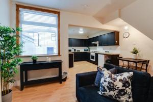 a living room with a couch and a kitchen at Poppy's Pad - Winchester Road in Liverpool