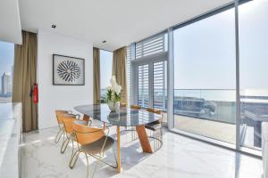 a dining room with a table and chairs at Luxe 3 BR Oceanfront Apt with maids room in the heart of Bluewaters Island in Dubai