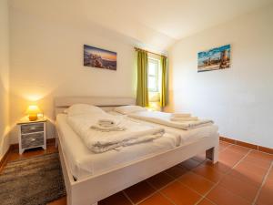a bedroom with two beds and a window at Feriendorf Rugana - Komfort Appartement mit 2 Schlafzimmern und Terrasse D03 in Dranske