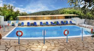 ein Pool mit blauen Stühlen und ein Gebäude in der Unterkunft Euro Park Hotel in Astris