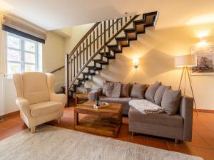 a living room with a couch and a staircase at Feriendorf Rugana - Komfortplus Appartement mit 2 Schlafzimmern und Terrasse D10 in Dranske +2 photos