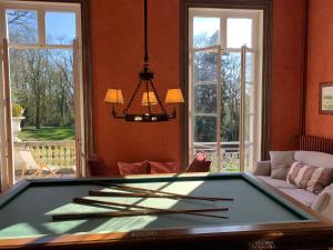 a pool table in a living room with windows at Domaine de Macque, BETZ, 25 mns Roissy CDG in Betz