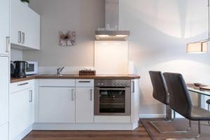 a kitchen with white cabinets and a sink and an oven at Villa Marin Wohnung 23 in Zinnowitz