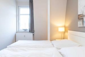 two white beds in a room with a window at Villa Marin Wohnung 23 in Zinnowitz +12 photos