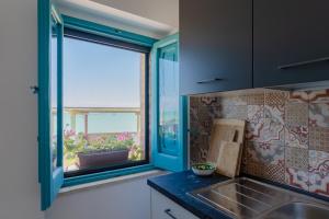 a kitchen with a sink and a large window at La casa di Maria - YourPlace Abruzzo in Fossacesia