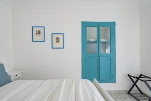 La casa di Maria - YourPlace Abruzzo في فوساتشيزيا: غرفة بيضاء مع خزانة زرقاء وسرير
