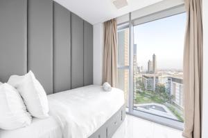1 dormitorio con cama blanca y ventana grande en Luxe 3 BR Oceanfront Apt with maids room in the heart of Bluewaters Island, en Dubái