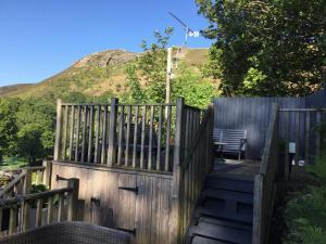 a wooden fence with a bench in front of a mountain at Woodbriar in Penmaen-mawr