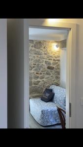 ein Schlafzimmer mit einem Bett und einer Steinmauer in der Unterkunft 4* Posta / Butiga couples only apartments in Vrbnik