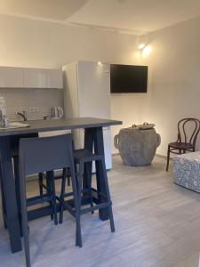 eine Küche mit einem Tisch und Stühlen sowie einem Kühlschrank in der Unterkunft 4* Posta / Butiga couples only apartments in Vrbnik
