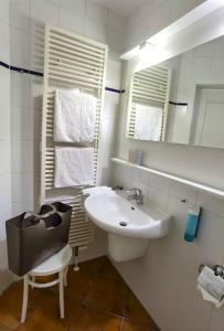 ein weißes Badezimmer mit einem Waschbecken und einem Spiegel in der Unterkunft Ferienwohnung Elke am Kurfürstensteg in Bad Saarow