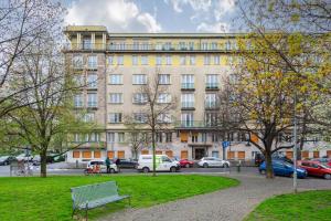 a building with cars parked in a parking lot at Lotus Apartment in Prague