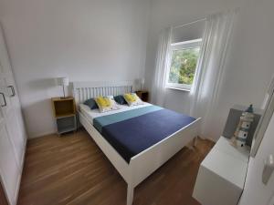 una camera bianca con un letto con una coperta blu di Korčula - apartman 1, Prigradica - IVAN a Blato