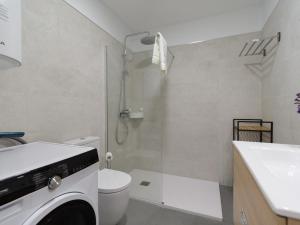 ein Badezimmer mit einem WC, einer Dusche und einer Waschmaschine in der Unterkunft Radiant Beach Accommodation in Guanarteme + 16 Fotos